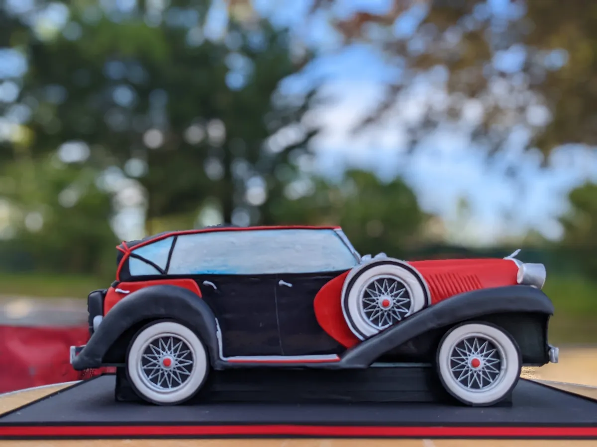 Carved cake shaped as a red and black antique car