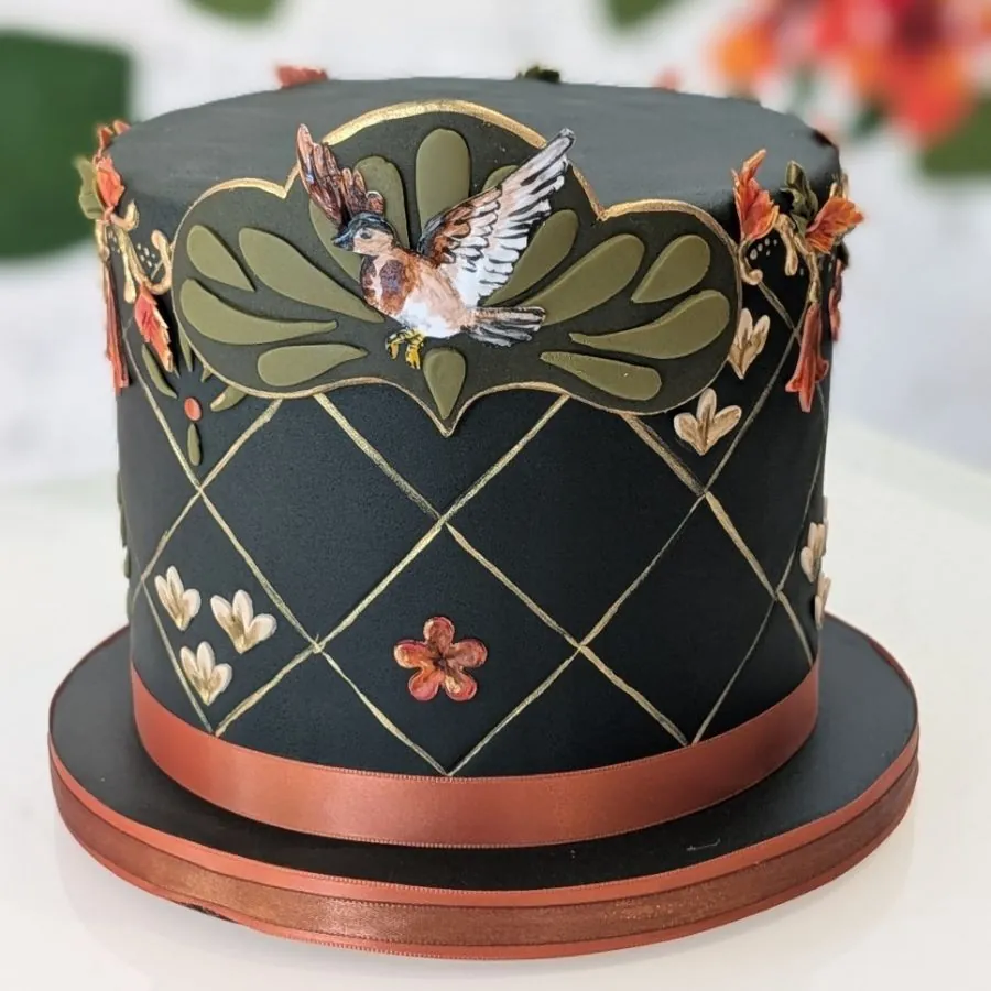 Black fondant cake with copper lattice and a sugar bird