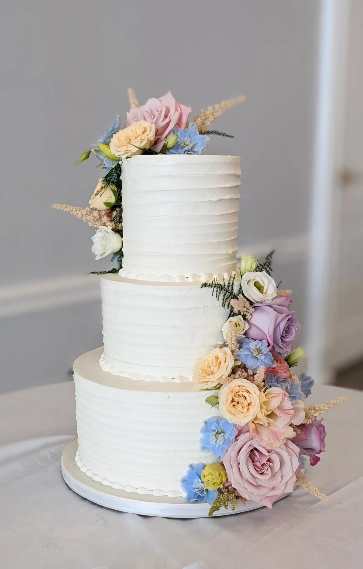 Three-tier buttercream cake with spring flowers
